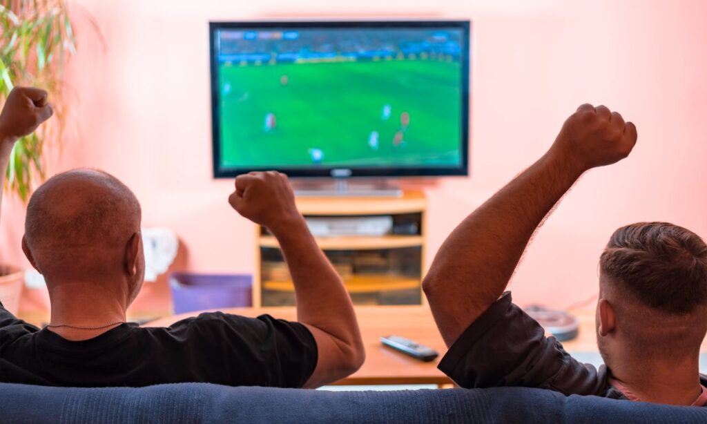 Pai e filho assistindo futebol